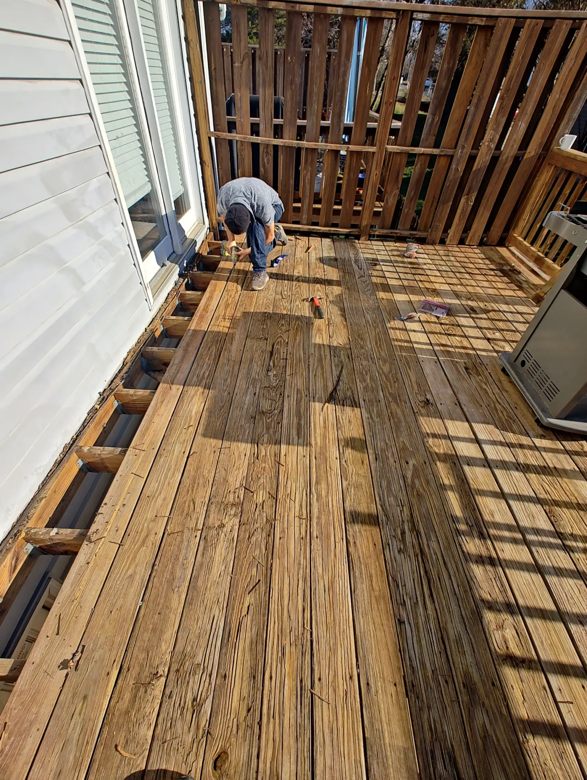 A professional worker installing a wood flooring outside.